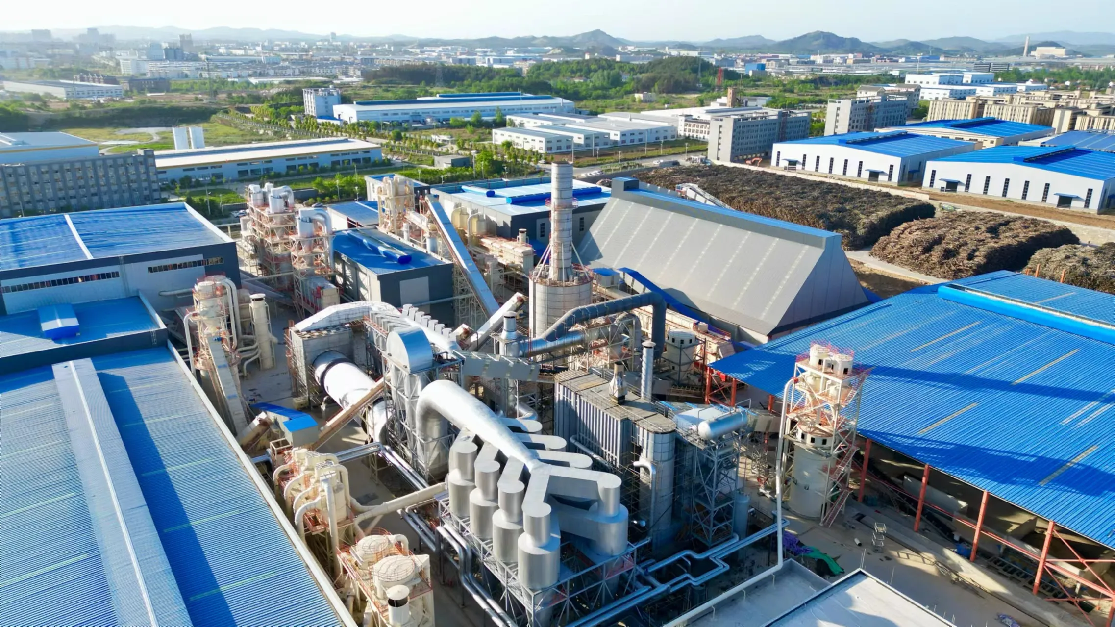 Aerial view of a Ningfeng production base: processing towers, chip storage and panel warehouses